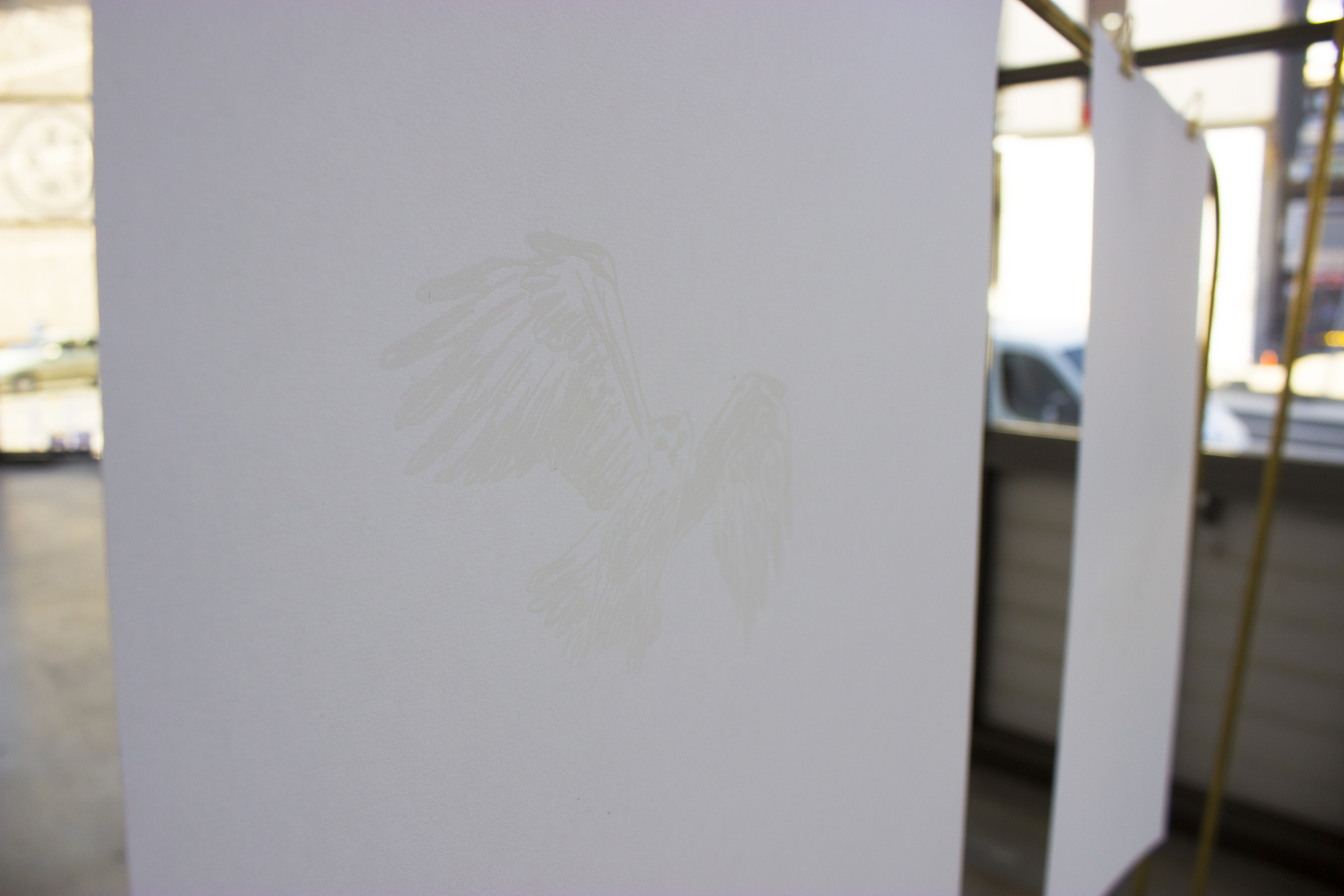 Sur une des feuilles, on voit une sérigraphie de chouette en blanc sur blanc.